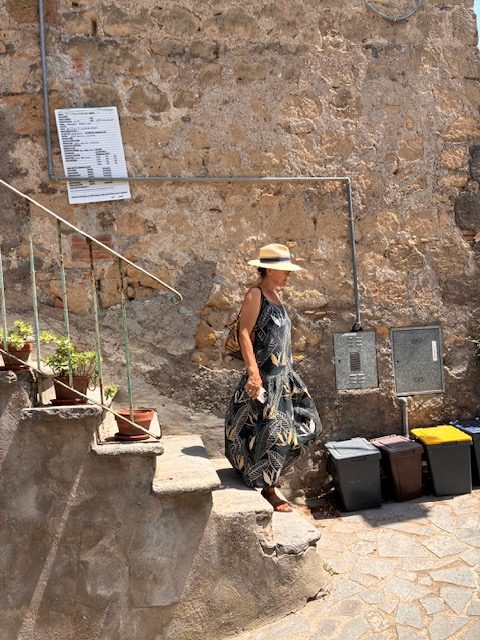 A woman in a straw hat on village steps