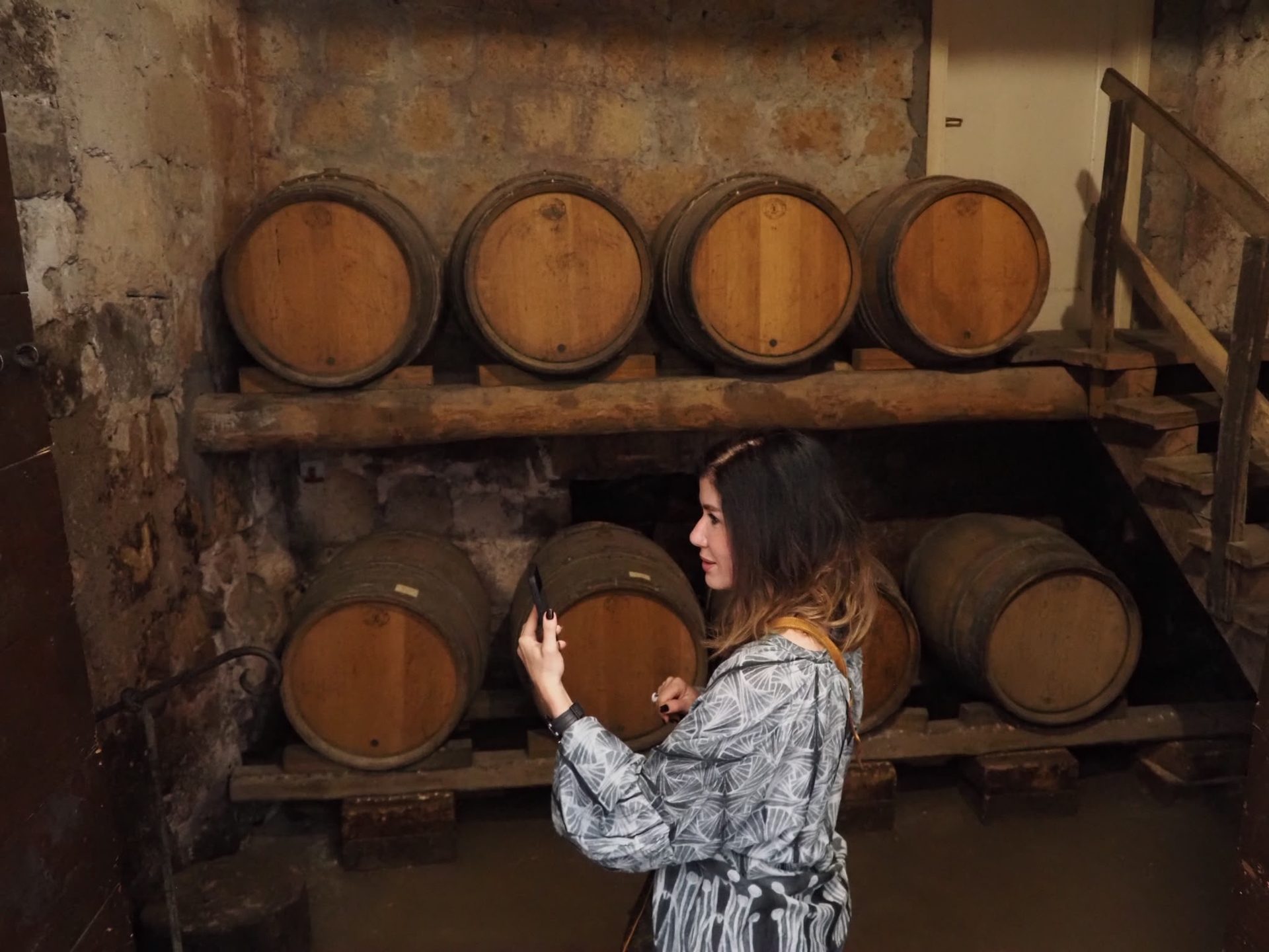 Checking the wine barrels in a stone cellar